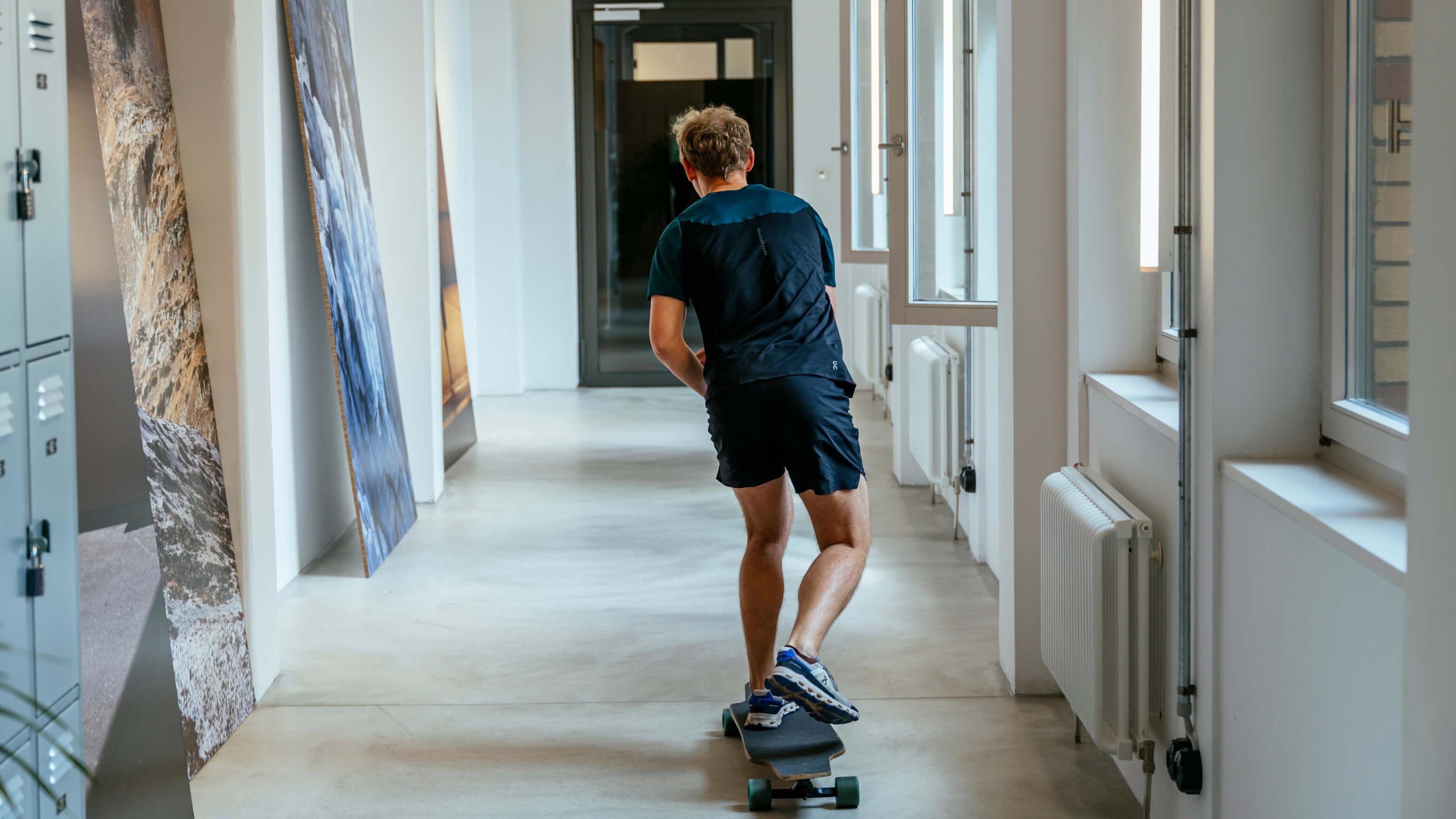 The guy skateboarding in the office hallway