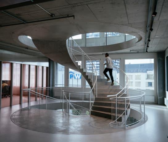A man walking up a spiral staircase