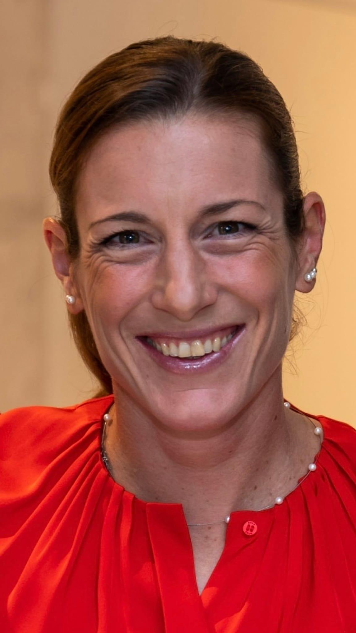 A portrait of a woman smiling at the camera.