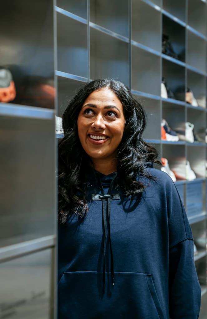 Woman looking up at the display of running shoes and smiling 