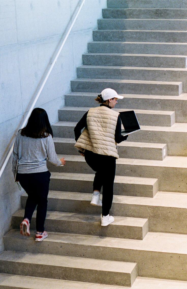 two women in athletic clothing walking up stairs