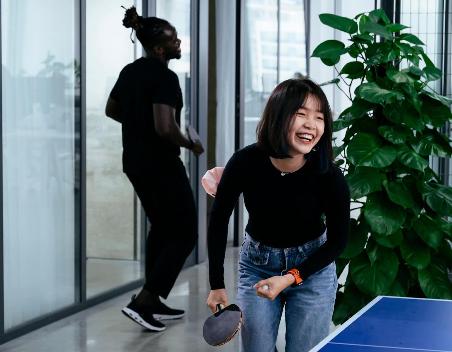 woman laughing and playing table tennis
